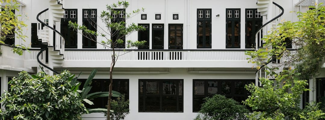 Modern white concrete Singapore landed home facade with glass windows